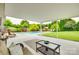 Relaxing covered patio with a view of the refreshing swimming pool, lush landscaping, and seating at 3903 Graywood Dr, Gastonia, NC 28052