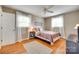 Bright bedroom with wood floors features neutral walls, light curtains, and a ceiling fan at 3903 Graywood Dr, Gastonia, NC 28052
