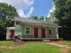Green home featuring a covered porch and two red doors at 424 Congress S St, York, SC 29745