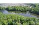 Aerial view showcasing a serene lake surrounded by lush trees and a distant neighborhood at 5064 Lassen Volcanic Trl, Lancaster, SC 29720