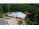 Aerial view of the community pool with ample lounge space and umbrellas, surrounded by trees at 5064 Lassen Volcanic Trl, Lancaster, SC 29720