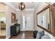 Elegant foyer featuring hardwood floors, a decorative mirror, and a stylish light fixture at 5064 Lassen Volcanic Trl, Lancaster, SC 29720