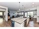 Bright open kitchen boasts a large island with granite countertop and stainless steel appliances, flowing into the adjacent living spaces at 5064 Lassen Volcanic Trl, Lancaster, SC 29720