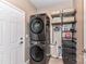 Efficient laundry room with stacked washer/dryer and shelving for organized storage solutions at 5064 Lassen Volcanic Trl, Lancaster, SC 29720
