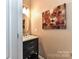 Stylish powder room with a black vanity, marble countertop, and decorative mirror at 5064 Lassen Volcanic Trl, Lancaster, SC 29720