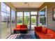 Cozy sunroom with bright orange furniture and screened windows overlooking backyard at 5064 Lassen Volcanic Trl, Lancaster, SC 29720