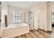 Bright bathroom with a tiled shower, soaking tub and a large window at 5832 Lagrande Dr, Charlotte, NC 28269