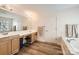 Bathroom with double sinks, wood flooring, a soaking tub, and ample storage at 5832 Lagrande Dr, Charlotte, NC 28269