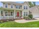 Inviting two-story home featuring a red front door, covered porch, and lush front yard at 5832 Lagrande Dr, Charlotte, NC 28269