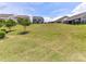 Wide shot of the green backyard showcasing manicured lawn, mature trees and distant view of other homes at 8035 Pastime Ln, Clover, SC 29710