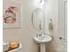 Powder room with pedestal sink, fish art and oval mirror at 8035 Pastime Ln, Clover, SC 29710