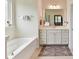 Clean bathroom showcasing a soaking tub, vanity with drawers, and large mirror at 8035 Pastime Ln, Clover, SC 29710