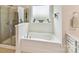 Bright bathroom featuring a glass enclosed shower, soaking tub and natural light at 8035 Pastime Ln, Clover, SC 29710