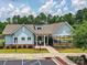 Exterior view of a modern, light-blue clubhouse with well-maintained landscaping, handicap parking, and accessible ramps at 8035 Pastime Ln, Clover, SC 29710