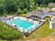 Aerial view of community pool area with lounge chairs, umbrellas, clubhouse, and playground at 8035 Pastime Ln, Clover, SC 29710
