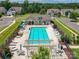 Aerial view of the community pool with lounge chairs, tables, umbrellas, and a nearby recreation building at 8035 Pastime Ln, Clover, SC 29710