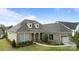 Beautiful brick home with lush landscaping, a two-car garage, and charming dormers on a clear, sunny day at 82120 Standing Oak Dr, Charlotte, NC 28278