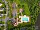Aerial view of neighborhood with a swimming pool and park in a green community with a lake at 10111 Snowbell Ct, Charlotte, NC 28215