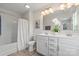 Bathroom featuring double sinks, tub, shower, and white cabinets at 10111 Snowbell Ct, Charlotte, NC 28215