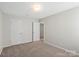 Carpeted bedroom featuring two doors and overhead lighting at 10111 Snowbell Ct, Charlotte, NC 28215