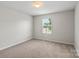 Bright bedroom featuring neutral carpeting, a window for natural light, and soothing paint at 10111 Snowbell Ct, Charlotte, NC 28215