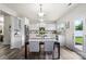 Open kitchen and dining area with stainless steel appliances and white cabinets at 10111 Snowbell Ct, Charlotte, NC 28215