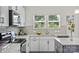Bright kitchen featuring stainless steel appliances, quartz counters, a window view, and gray subway tile backsplash at 10111 Snowbell Ct, Charlotte, NC 28215