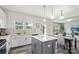Bright open concept kitchen, with an island, white cabinets, and an adjacent dining area at 10111 Snowbell Ct, Charlotte, NC 28215