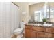 Cozy bathroom featuring granite countertop, wood cabinets, and shower-tub combination at 10129 Loch Lomond Dr, Charlotte, NC 28278