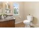 A well-lit bathroom featuring a granite countertop, toilet, and a window providing natural light at 10129 Loch Lomond Dr, Charlotte, NC 28278