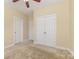 Bedroom showcasing neutral paint, plush carpet, a ceiling fan, and ample closet space at 10129 Loch Lomond Dr, Charlotte, NC 28278