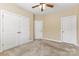 Neutral carpeted bedroom with ceiling fan, closet, and white doors for a clean and bright design at 10129 Loch Lomond Dr, Charlotte, NC 28278