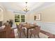 Formal dining room featuring a modern chandelier, wainscoting, large windows, and seating for six at 10129 Loch Lomond Dr, Charlotte, NC 28278