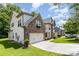 Charming two-story home with stone and vinyl siding, featuring manicured lawn and flower boxes adding to curb appeal at 10129 Loch Lomond Dr, Charlotte, NC 28278