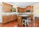 This is a kitchen with wood cabinets, granite counters, stainless steel appliances, and cherry wood floors at 10129 Loch Lomond Dr, Charlotte, NC 28278