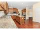 Kitchen with stainless steel appliances, wood cabinets, granite countertops, and an island with stools at 10129 Loch Lomond Dr, Charlotte, NC 28278