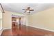 Cherry wood floors, a ceiling fan, and open access to the kitchen in this house's living room at 10129 Loch Lomond Dr, Charlotte, NC 28278