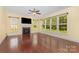Living room featuring a fireplace, a ceiling fan, many windows that bring in lots of light, and cherry wood floors at 10129 Loch Lomond Dr, Charlotte, NC 28278