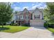 Charming two-story home boasts stone accents, red shutters, and a manicured lawn at 10203 Loch Lomond Dr, Charlotte, NC 28278