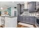 Modern kitchen with stainless steel oven, white countertops, gray cabinets, and hardwood flooring at 10203 Loch Lomond Dr, Charlotte, NC 28278