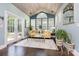 Bright sunroom with a vaulted ceiling, multiple windows, a yellow sofa, and hardwood floors at 10203 Loch Lomond Dr, Charlotte, NC 28278
