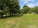 Picturesque view of the open backyard with trees and green grass at 1025 Old Us 80 Hwy, Gold Hill, NC 28071