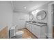 Bathroom with white vanity and dual sinks, mirrors, and updated fixtures next to a toilet at 1025 Old Us 80 Hwy, Gold Hill, NC 28071
