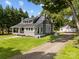View of the house with metal roof, covered porch with swing, and a detached garage at 1025 Old Us 80 Hwy, Gold Hill, NC 28071