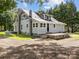 Charming two-story home with a metal roof, painted gray exterior, and a graveled yard surrounded by trees at 1025 Old Us 80 Hwy, Gold Hill, NC 28071