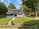 Beautiful single-Gathering home featuring a metal roof, covered front porch with swing, and a lush green lawn at 1025 Old Us 80 Hwy, Gold Hill, NC 28071