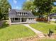 Attractive home showcasing a metal roof, covered porch with a swing, and a stone walkway through the green lawn at 1025 Old Us 80 Hwy, Gold Hill, NC 28071