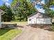 View of the detached garage with a gravel driveway, close to the main home on a grassy lot at 1025 Old Us 80 Hwy, Gold Hill, NC 28071