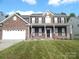 Classic brick two-story home with black shutters, attached garage, and manicured front lawn at 10615 Elm Bend Dr, Charlotte, NC 28273