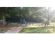 Fenced playground featuring slides, swings, and climbing structures in a shady, natural setting at 12314 Chickasaw Dr, Huntersville, NC 28078